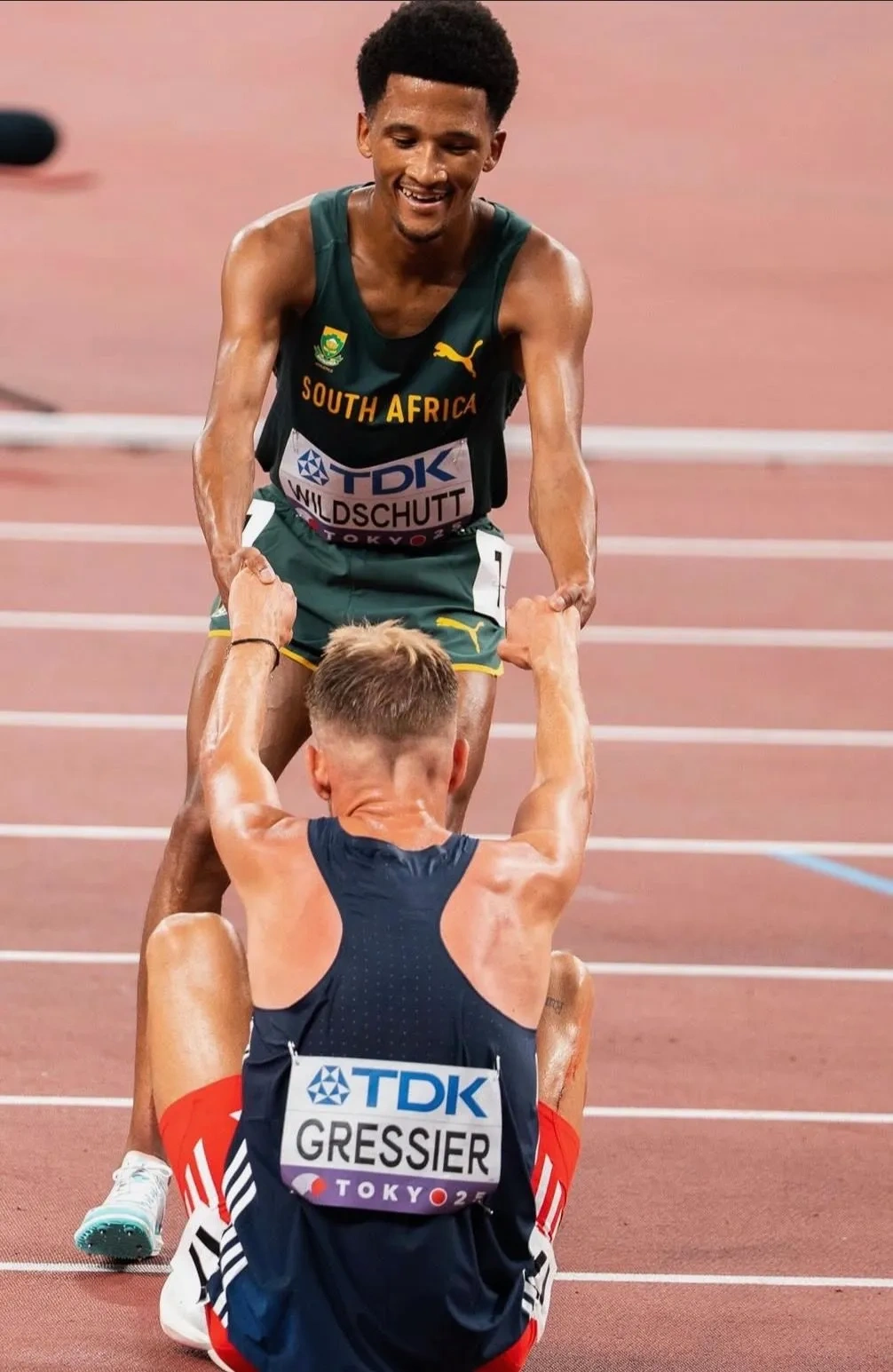 Adrian Wildschutt pulling fellow finisher Gressier up after the Tokyo 25 final